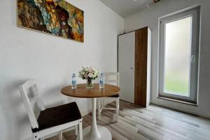 a dining room with a table and a vase of flowers at Nori Studio #Garden&Pool in Ştefăneştii de Sus