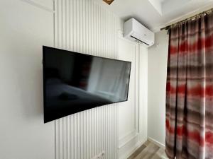 a flat screen tv hanging on a wall at Nori Studio #Garden&Pool in Ştefăneştii de Sus