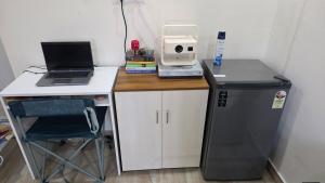 a small desk with a laptop and a computer on it at Rewind by NestoraHomes in Jadgenhalli