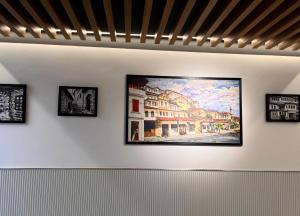 a painting on a wall with four pictures on it at Mili Hotel in Berat
