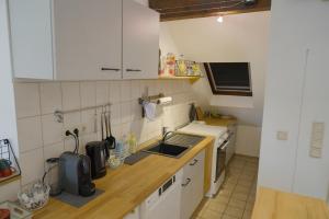 a small kitchen with white cabinets and a sink at Dachgeschosswohnung in Hannover