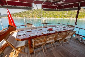 a table and chairs on a boat in the water at Cakabey Yachting in Demre