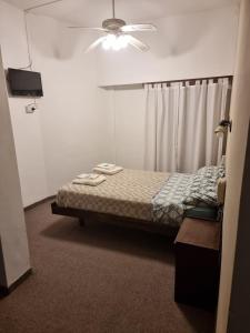 ein Schlafzimmer mit Bett und Deckenventilator in der Unterkunft Bahia Ourense Hotel in San Clemente del Tuyú