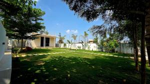 a yard with a fence and a house at Rewind by NestoraHomes in Jadgenhalli