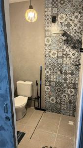 a bathroom with a toilet and a tile wall at Aloha Guest House in Fortaleza +28 photos