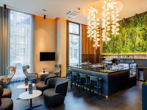 a hotel lobby with a bar and chairs at Movenpick Hotel Tallinn in Tallinn