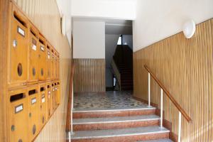 a hallway with stairs and lockers in a building at La casetta di Leo in Poggibonsi