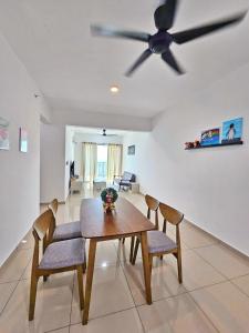 a dining room table with chairs and a ceiling fan at Metropol Holiday Suite in Bukit Mertajam