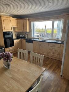 a kitchen with a table with chairs and a window at Erne View Lodge in Lisnaskea