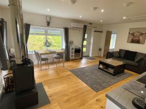 a living room with a couch and a table at Rha Ha Cottage in Uig
