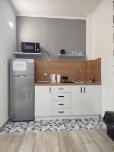 a kitchen with white cabinets and a refrigerator at Mejdan II in Mostar +5 photos