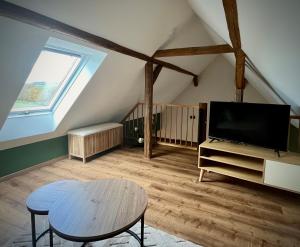 a living room with a tv and a table at Ferienhaus Schwalmblick in Schwalmstadt