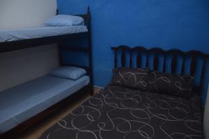 a bedroom with two bunk beds and a blue wall at Conforto e Paz, pertinho do mar! in Caraguatatuba