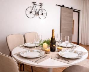 a white table with a bottle of wine and a bike at Maison cosy citadine in Tours