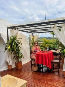 a woman sitting at a table on a deck at Barichara Glamping in Barichara