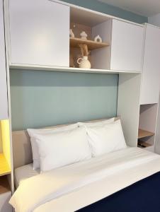 a bed in a room with white cabinets and white pillows at A l'orée de Croix - AbsoluteHome in Croix