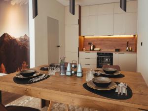 a wooden table with plates and bowls on it in a kitchen at A-Apartment in Gjakove