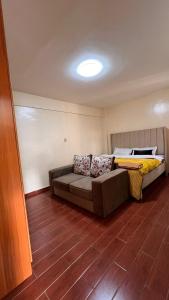 a room with a couch and a bed in it at Kaisa Gardens in Nairobi