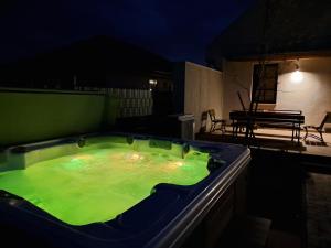 a jacuzzi tub with green liquid in it at night at Vadgesztenyés Vendégház in Lipót