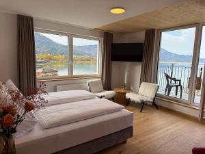 a bedroom with a bed and a large window at Seehotel Lilly in Strobl