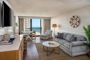 a living room with a couch and a table at Ashore Oceanfront Hotel by Marriott in Ocean City