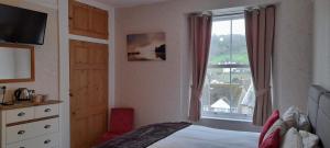 a bedroom with a bed and a window at Saffron House in Combe Martin