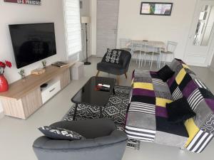 a living room with a couch and a tv at Maison au calme proche accès rocade in Montauban