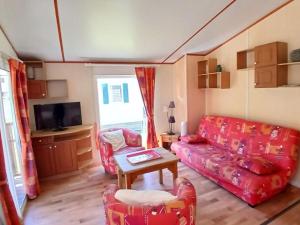a living room with a couch and a table at Chalet confortable avec terrasse - 6 pers. - API-1-52-2004 in Saint-Oyen +9 photos