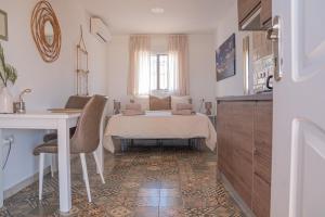 a bedroom with a bed and a table and a desk at Finca Feliz Andaluz in Alora