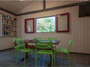 a dining room with a table and green chairs at Chalet confortable avec terrasse - 6 pers. - API-1-52-2004 in Saint-Oyen