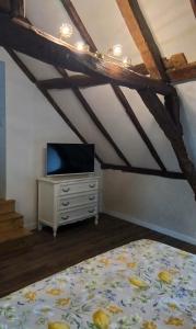 a bedroom with a bed and a tv on a dresser at Bed and Breakfast en Sarthe in Avoise