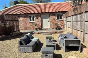 a patio with two couches and a table in front of a building at Torworth - 1 Bed Barn - Sleeps 3 - Hot Tub in Torworth