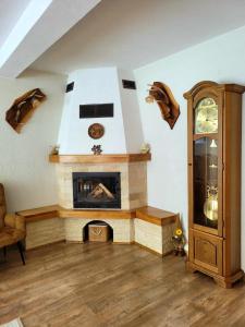 a living room with a fireplace and a clock at Cabana Valea Muntelui in Poiana Mărului