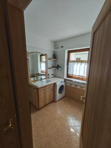 a bathroom with a sink and a washing machine at MB Appartamento in Santo Stefano di Cadore +11 photos