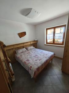 a bedroom with a bed and a window at MB Appartamento in Santo Stefano di Cadore