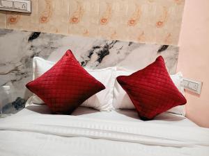 a bed with two red pillows on it at Hotel Udaan Stay in Jaipur