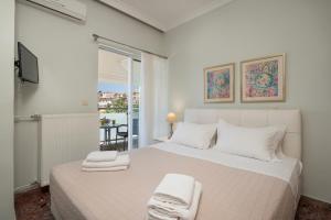 a bedroom with a large white bed with towels on it at Apartments Chania in Chania