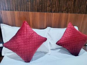two pink pillows sitting on top of a bed at Hotel Udaan Stay in Jaipur +9 photos