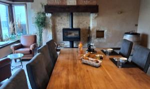 a dining room with a wooden table and a couch at Bed and Breakfast en Sarthe in Avoise