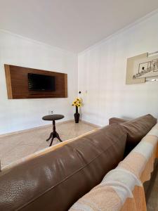 a living room with a brown couch and a table at Chacara Souza in Socorro