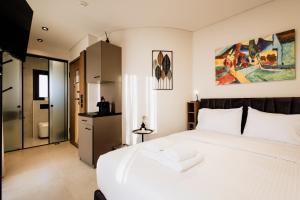 a bedroom with a large white bed and a bathroom at Dreamer's Luxury Suites in Volos