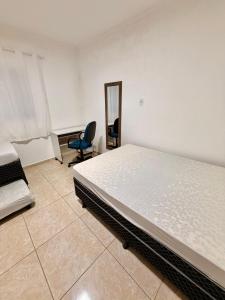 a bedroom with a bed and a mirror and a chair at Chacara Souza in Socorro +6 photos