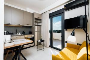 a kitchen and living room with a yellow couch and a table at Dreamer's Luxury Suites in Volos