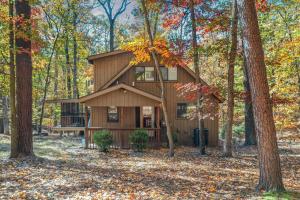 a cabin in the woods with trees at Dog-Friendly A-Frame with Hot Tub and Firepit in Hedgesville