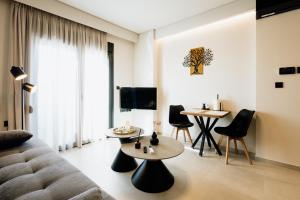 a living room with a couch and a table and chairs at Dreamer's Luxury Suites in Volos
