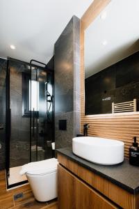 a bathroom with a white sink and a shower at Dreamer's Luxury Suites in Volos +86 photos