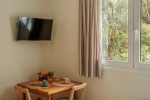 a room with a table and a television on a wall at AROI Studio in Patra