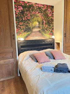 a bedroom with a bed with a painting of flowers at Snow&Rose in Damme