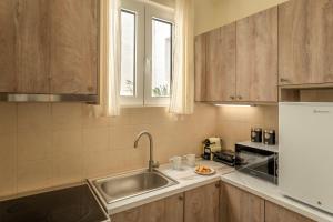 a kitchen with wooden cabinets and a sink at AROI Studio in Patra