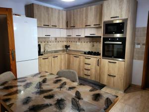a kitchen with wooden cabinets and a table with a table sidx sidx sidx at Cabana Valea Muntelui in Poiana Mărului